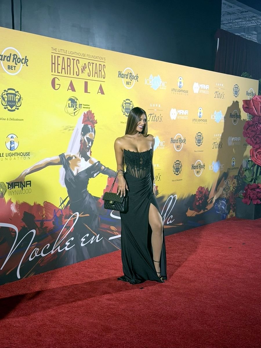 Guest posing at the Hearts and Stars Gala step and repeat